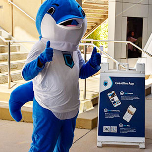 dolphin mascot outside giving thumbs up